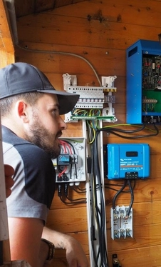 Technicien Vilma Solaire effectuant le raccordement d'une installation photovoltaïque dans un local technique